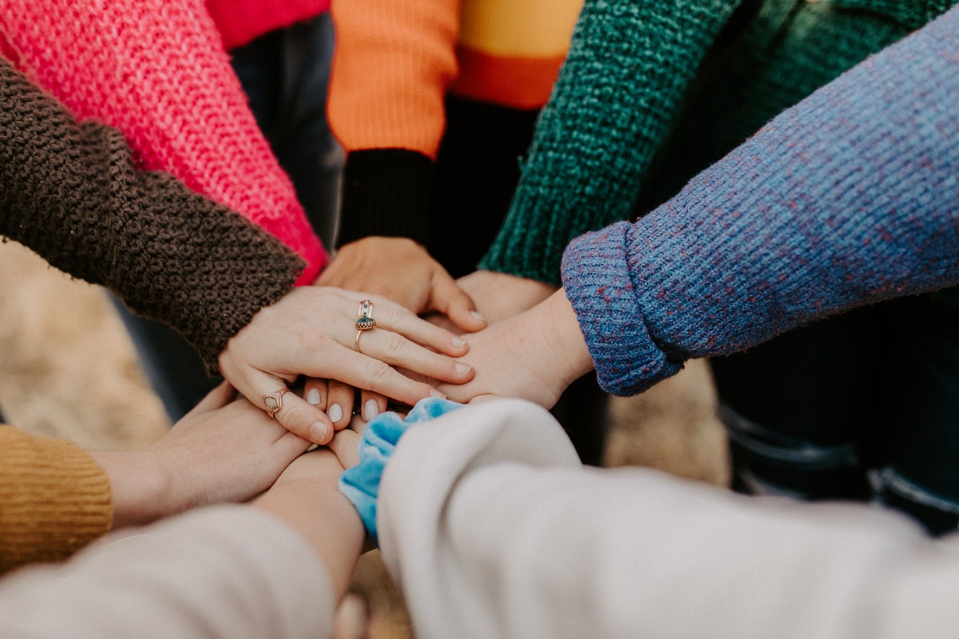 A photo of hands placed onto of each other in solidarity.