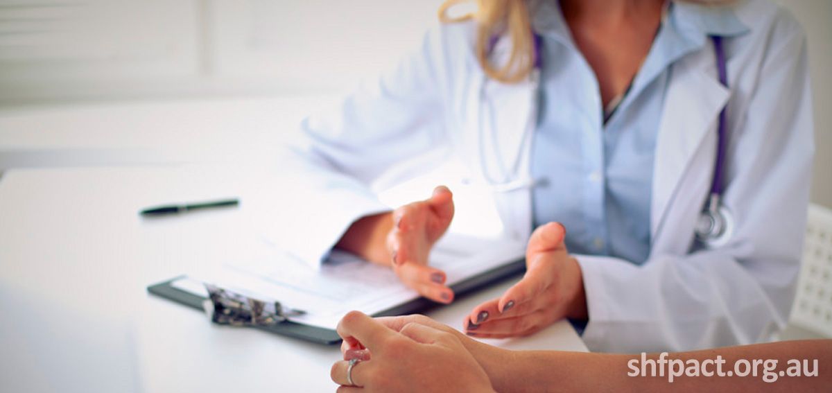 A close up of a female doctors while she talks to another female patient.