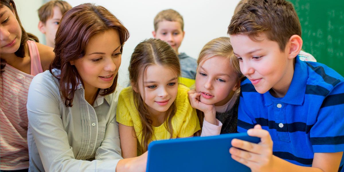 Young students with teacher looking at a iPad