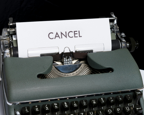 A type writer with a piece of paper that reads cancel