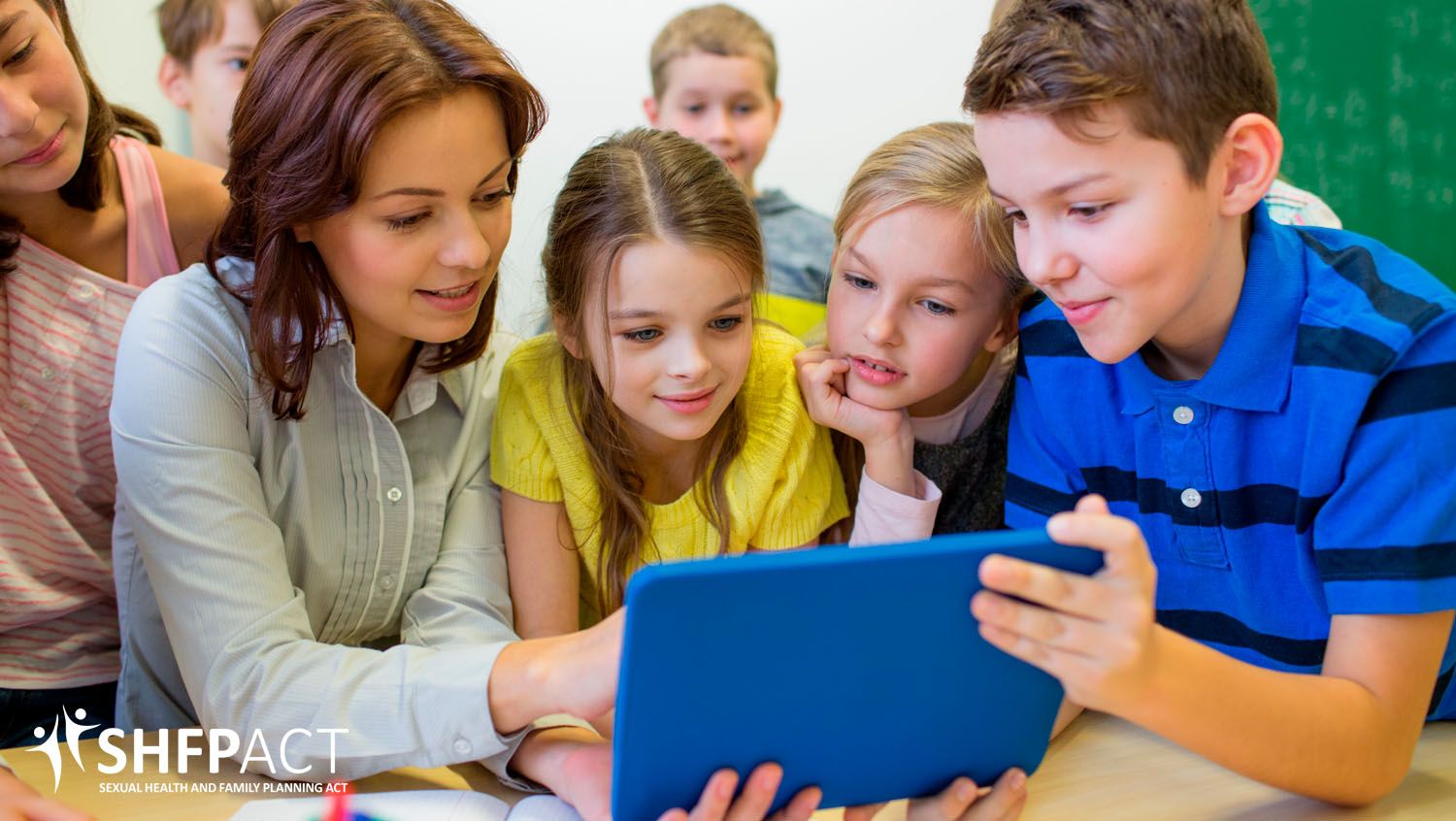 Young students with teacher looking at a iPad